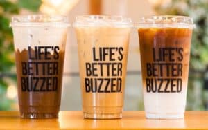Better Buzz Coffee in Brandon iced drinks with Life's Better Buzzed cups on wooden counter